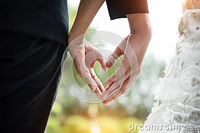 The wedding couple is making love hand sign together,heart sign by hand Stock Photo