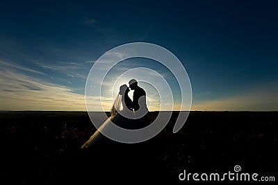 wedding couple with the sunset. Silhouette of Bride and Groom kissing on the romantic wedding Stock Photo