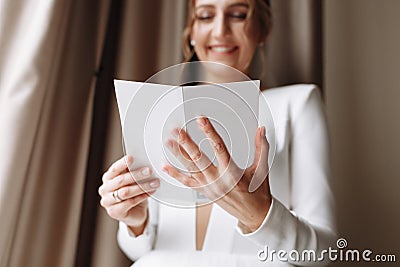 Wedding day. Fees at the hotel. the bride near the window and reads the letter to the groom. Wedding vows. Preparations. Morning Stock Photo