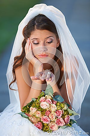 Wedding day jitters. a young bride looking upset while sitting down and holding her bouquet. Stock Photo