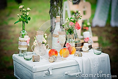 Wedding decor with bottles, glasses, roses, vases and peaches on Stock Photo