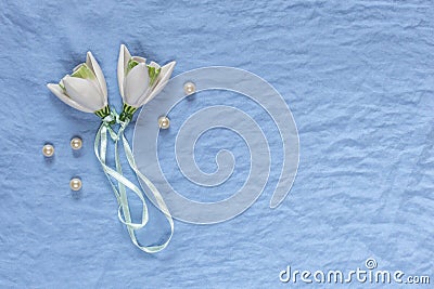 Wedding decor. White ceramic flowers, pearls on a blue fabric ba Stock Photo