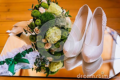 Wedding details, green Bridal bouquet, shoes, bride garter and earrings Stock Photo