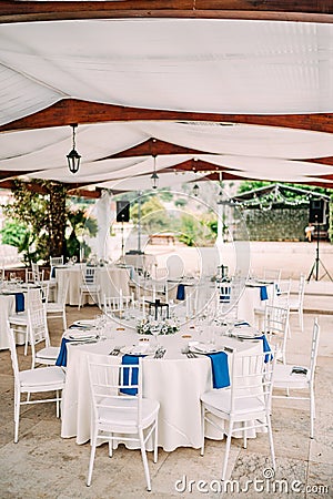 Wedding dinner table reception. Round banquet table with white tablecloth and white Chiavari chairs. Wedding under the Stock Photo