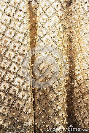 Wedding dress fabric texture background. Golden and ivory silk dress with beads, pearls, sparkles and embroidery. Vintage dress Stock Photo