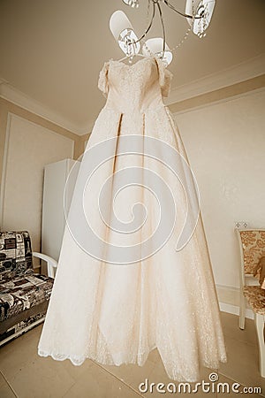 Wedding dress on hanger in the bride room. On her wedding day Stock Photo