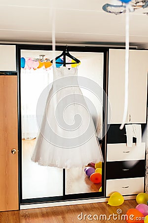 Wedding dress on a hanger on the mirror background Stock Photo