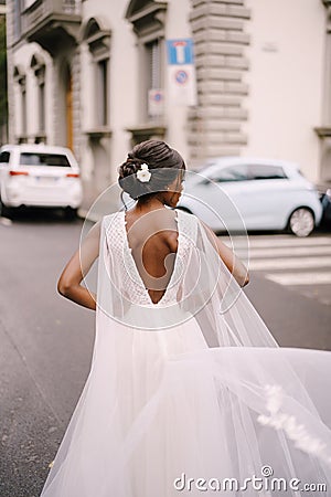 Wedding in Florence, Italy. African-American bride, Back to the camera, in a white dress, with a long veil, walks along Stock Photo