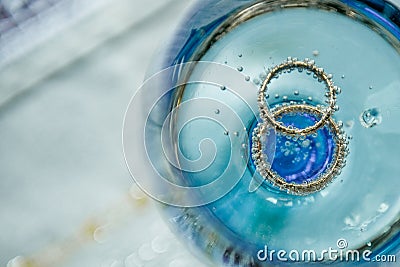 Wedding golden rings in glass of champagne. Stock Photo