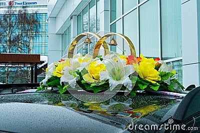 Wedding rings among flowers on the top of a wedding car Editorial Stock Photo