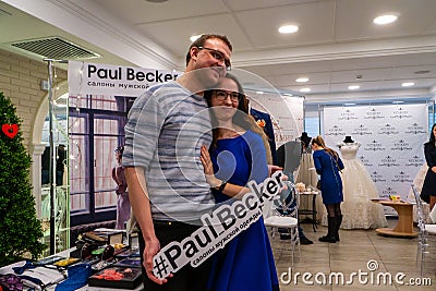 A gonna be married pair posing for the camera with Paul Becker logo Editorial Stock Photo