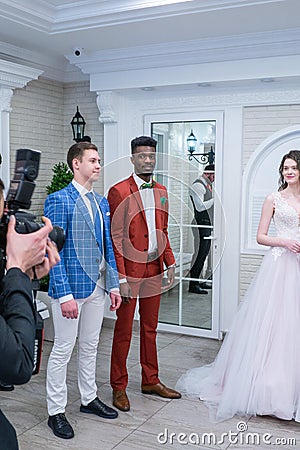 A pair of groom models posing for the camera in wedding suits Editorial Stock Photo