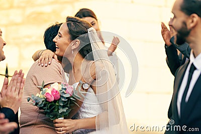 Wedding, marriage and bride hug family guests with a smile while leave church with groom after marrying, celebration and Stock Photo