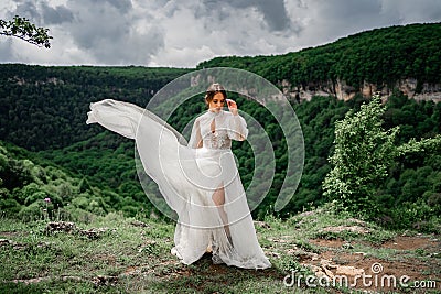 wedding photo shoot in the mountains. the bride in flutters skirt on the meadow. Stock Photo