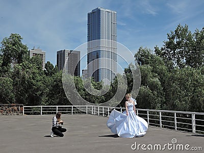 Wedding photographer takes pictures of the bride on the background of the urban landscape, fine art photos. Russia, Saratov - June Editorial Stock Photo