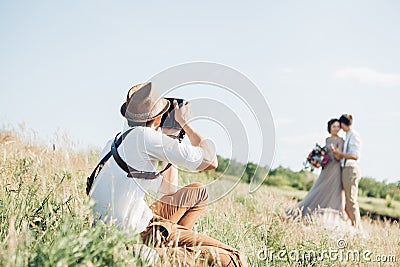 Wedding photographer takes pictures of bride and groom in nature, fine art photo Stock Photo