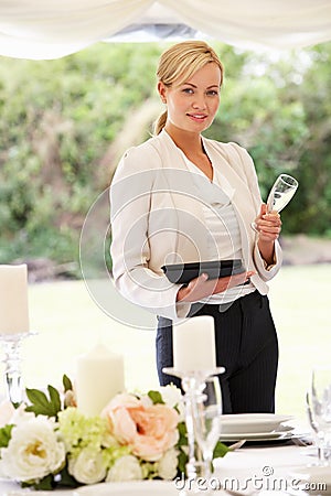 Wedding Planner Checking Table Decorations In Marquee Stock Photo