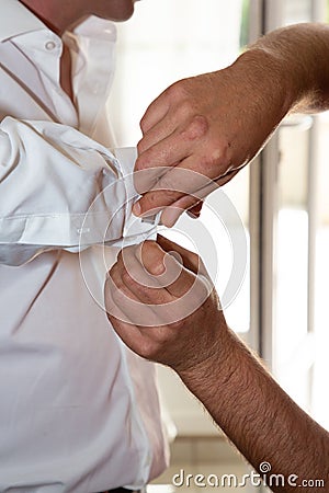 Wedding preparing the groom with the cufflinks Stock Photo