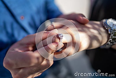 Wedding proposal, a man putting a ring on a woman`s finger | Couple in love and getting married Stock Photo