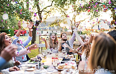 Bride and groom with guests at wedding reception outside in the backyard. Stock Photo