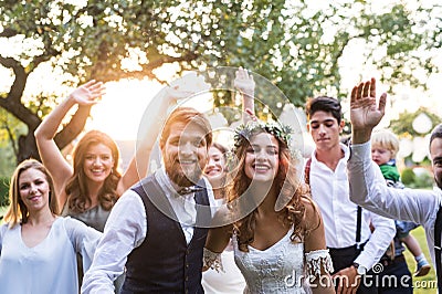 Bride, groom, guests posing for the photo at wedding reception outside in the backyard. Stock Photo