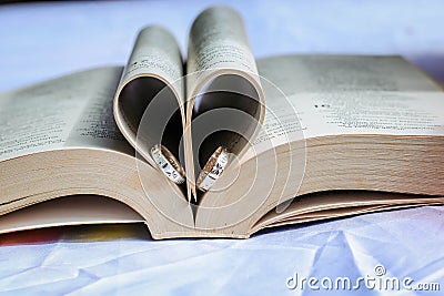 wedding ring in a heart shape bible pages Stock Photo
