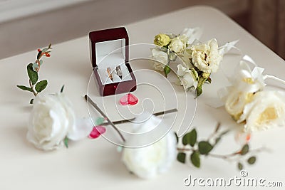 Wedding rings in a beautiful wooden box. Floral arrangement with white roses. Stock Photo