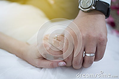 Wedding rings on bride and groom`s hands.engaged couple holding hands with diamond and silver ring Stock Photo