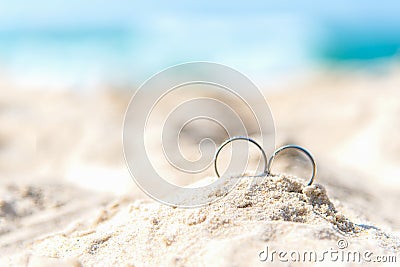 Wedding rings for couple lover on the sandy beach. Engagement rings in honeymoon vacation in tropics. Valentine Concept. Stock Photo