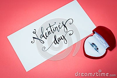 Wedding rings and envelope words valentine day on pink background Stock Photo