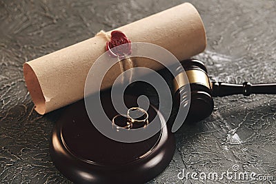 Wedding rings on the figure of a broken heart from a tree, hammer of a judge on a wooden background. Divorce divorce Stock Photo
