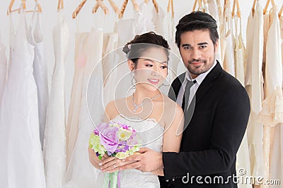 Wedding shopping lifestyle Concept, beautiful Asian girl show dress to groom making decision for wedding ceremony, man help woman Stock Photo