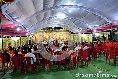 Wedding stage for jai mala prograamme with green carpet red chair and white coulor roof silver front, Editorial Stock Photo