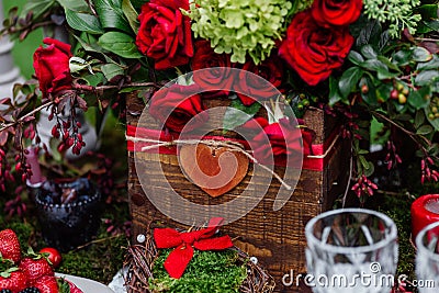 Wedding table decor: flowers composition with roses,berries, herbs and greenery standing in wooden box. Bridal details and decorat Stock Photo
