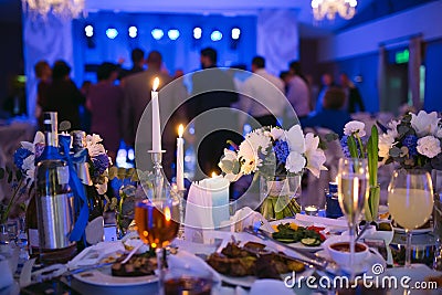 Wedding table settings in the restaurant. People dancing in the background of the Bridal table. Stock Photo