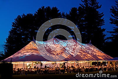 Wedding tent at night - Special event tent lit up from the inside with dark blue night time sky and trees Editorial Stock Photo