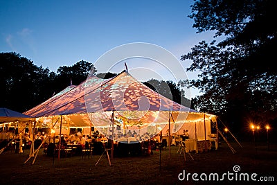 Wedding tent at night - Special event tent lit up from the inside with dusk sky and trees Editorial Stock Photo