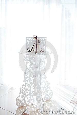 Wedding white openwork wooden box on a white tracery stand. concept of wedding decor Stock Photo
