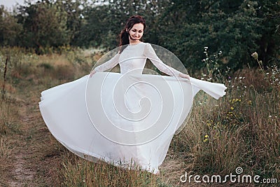 Wedding. Young beautiful bride with hairstyle and makeup posing in white dress. Stock Photo