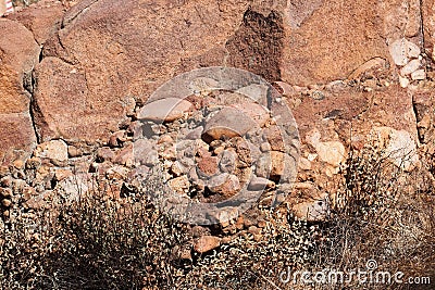 A WEDGE OF CONGLOMERATE ROCK AT THE BASE OF A LARGE BOULDER Stock Photo