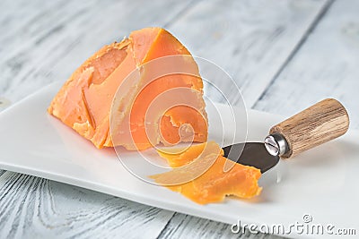 Mimolette cheese on white plate Stock Photo