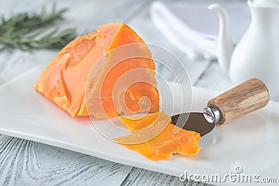 Mimolette cheese on white plate Stock Photo