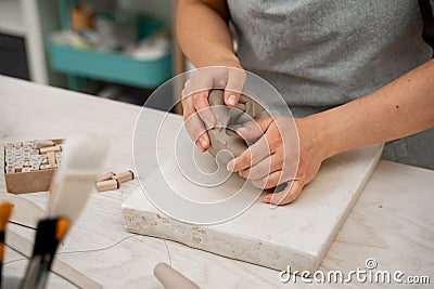 Wedging the clay before starting making a pottery project to create proper consistency. Removing air bubbles from clay Stock Photo