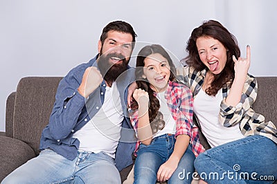 Weekend finally. Little girl relaxing with parents. Stay at home. Family sit on couch. Happy father mother and daughter Stock Photo
