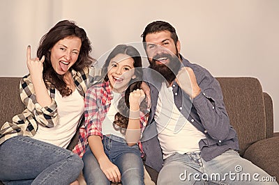 Weekend finally. Little girl relaxing with parents. Stay at home. Family sit on couch. Happy father mother and daughter Stock Photo