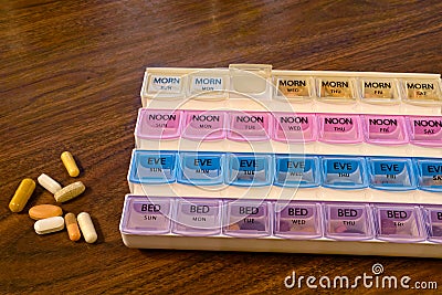 A weekly pill container and pills Stock Photo