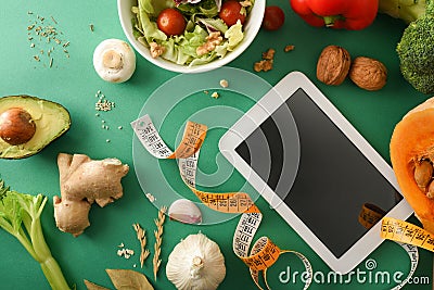 Weight control planning with blank electronic device on green table Stock Photo