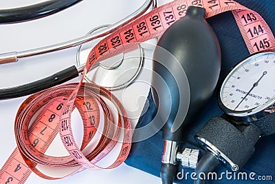Weight gain or loss and high or low blood pressure concept. Measuring tape, stethoscope and sphygmomanometer. Effect of obesity, i Stock Photo