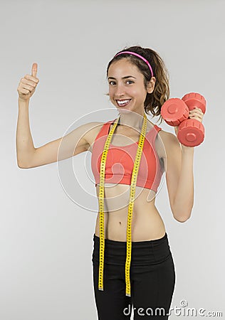 Weight loss woman with dumbbells giving thumbs up Stock Photo