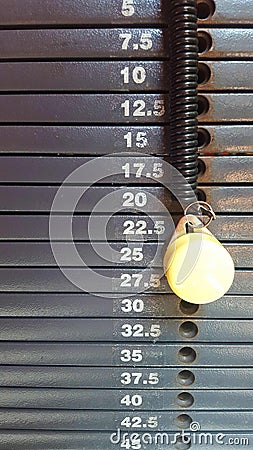 Weight stack gray scale with graduation in kilograms with yellow pin Stock Photo